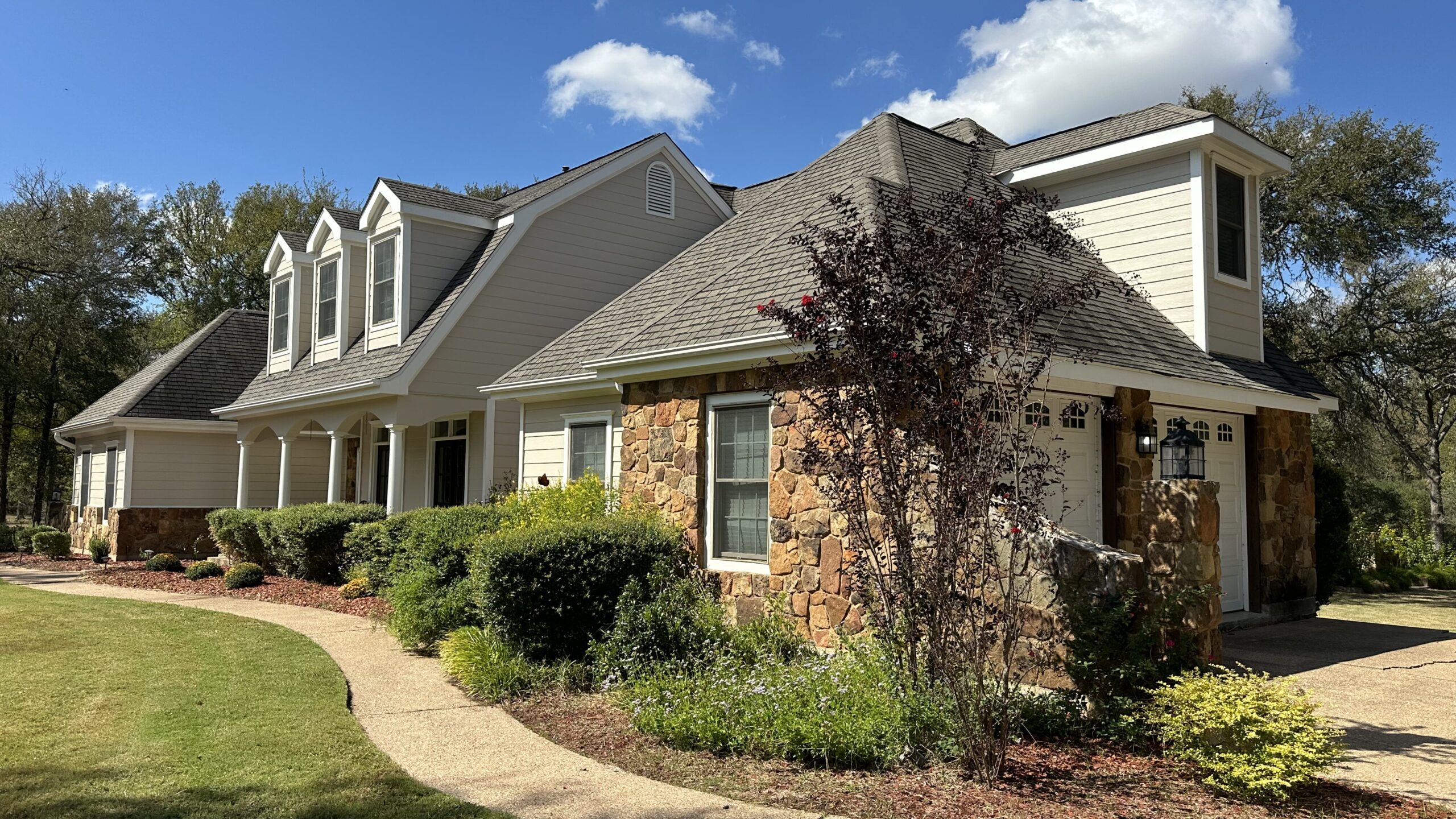 Central Texas home exterior with stone accents and landscaped front yard.